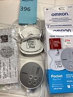 TENS unit, electrode pads, manual, bubble wrap and box overview