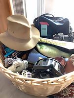 Basket overview showing hat, camera bag, controllers, VMU, Big Mouth Billy Bass box, goggles and basket