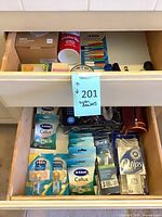 Overview of both drawers showing callus remover packs, OneBlade blades, Oral-B floss, Q-tips, flashlights, and shaving cream