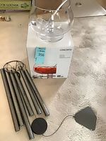 Punch bowl on box with ladle; six-tube wind chime components beside