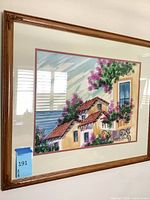 Full view of framed Mediterranean village artwork showing frame, matting, glass