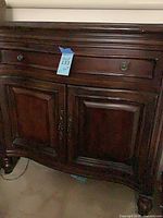Front view showing full piece, drawer, doors, hardware
