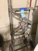 Full view of steel hand truck with straps and wheels