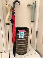 Full view of umbrella stand with umbrella and two decorative stakes