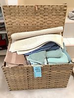 Open wicker chest showing towels and bath mats inside