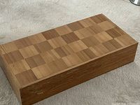 Closed folding chessboard/storage box showing inlaid wood squares