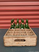 Front view of wooden 24-slot crate with 11 bottles inserted