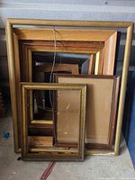 Stack of assorted wood and gilt frames showing size range and finishes