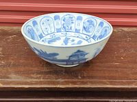 Side view of blue and white porcelain bowl showing exterior landscape design