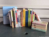 Full group of approximately twenty-three books standing and stacked