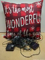 Front view of pillow and tangled solar string lights with two solar panels