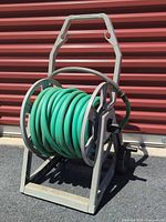 Front view of gray Craftsman Hosemobile reel cart with green hose coiled