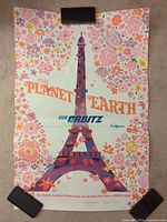 Full view of folded Orbitz Eiffel Tower poster held with clips
