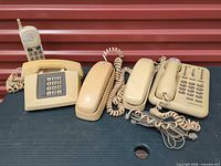 Group shot of five beige phones showing overall lot contents