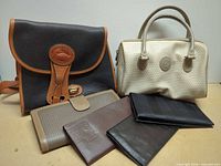 Group shot of Dooney & Bourke bag, Caribou satchel and four wallets