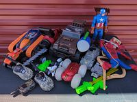 Overall view of mixed toy lot with figures, vehicles, accessories