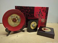 Entire set: red plate on stand, two black boxes, outer presentation box