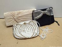 Three evening bags together showing size, colors and overall styles