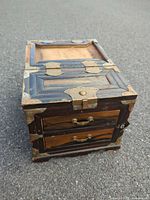 Front view of wooden jewelry chest with brass hardware