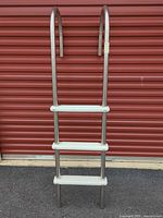 Full frontal view of stainless steel pool ladder showing three steps