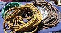 Coiled green, yellow and brown air hoses with coupler in package beneath