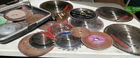 overview of multiple circular saw blades and cutoff wheels on table and partially in case