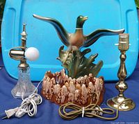 Front view of three lamps: ceramic mallard, crystal lamp, brass lamp
