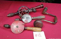 Four vintage hand drills on red backdrop