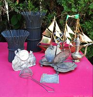 Entire lot grouped on table: brass ship, clock, ewer, two tall candle holders, inkwell stand, egg separator, Flik mold