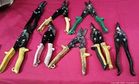All eight aviation snips laid out on red background