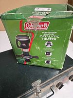 Boxed Coleman PerfectTemp SportCat catalytic heater sitting on metal stove