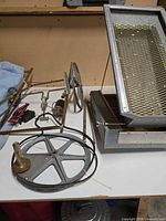 Overview showing shaker box, mesh screen, motor, pulleys and frame parts on tabletop