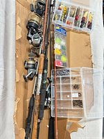 Group of rods, reels, tackle boxes and lures laid out in box