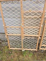 Front view of three wooden expandable safety gates leaning against wall