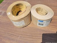Two sandpaper rolls side by side on table