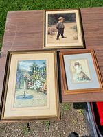 Overview of the three framed prints on table