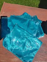 Stack of packaged teal table runners on table under sunlight