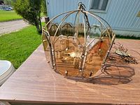 Overall view of brass chandelier with smoked glass panels and swag chain on tabletop