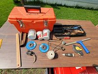 Overall view showing orange Castex toolbox, removable tray and array of tools and supplies laid out