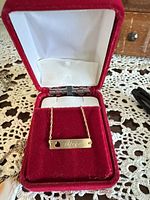 Gold bar bracelet in red box, full view