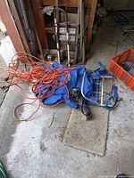 Lot overview showing extension cord, blue bag with frame and black adapter