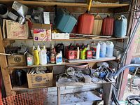 Full shelving with chemicals, jerry cans, duct fittings, rope, power tools