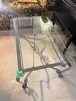 Overall view of glass top coffee table on wrought iron base