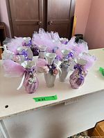 Group of 12 small, decorated vases with tulle and faux flowers