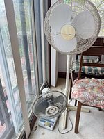 Holmes pedestal fan and accompanying items by window