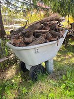 Full view of grey plastic garden cart loaded with firewood