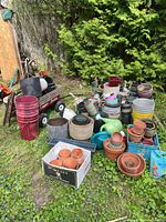 Overall lot showing Radio Flyer wagon, stacked plant pots, watering cans, buckets