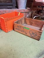 wooden crate and orange plastic crate side by side