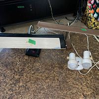Overview showing black desk lamp with white bar head, brown gooseneck lamp, and white dual spot fixture