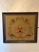 Full view of framed needlepoint artwork on wall